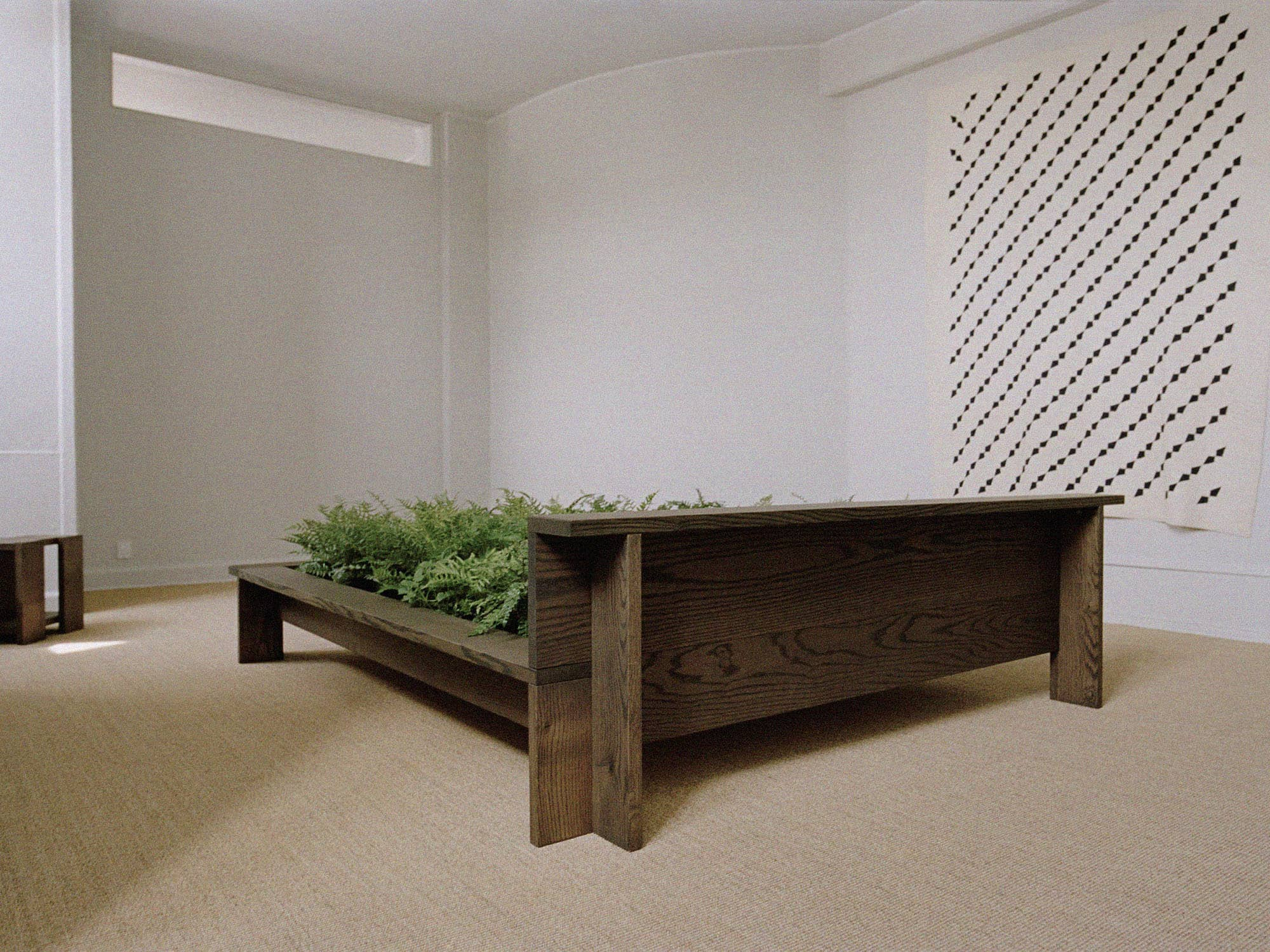 rye-hem-smoked-red-oak-bed-frame-with-ferns-in-showroom-cph